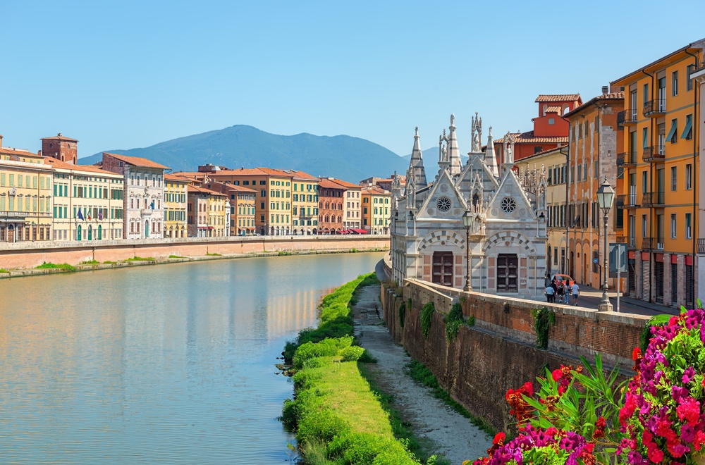 Gotycki kościół Santa Maria della Spina nad Arno w Pizie, w tle kolorowe kamienice