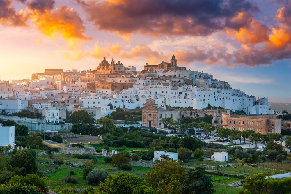 Białe miasto Ostuni na wzgórzu o zachodzie słońca, w prowincji Brindisi