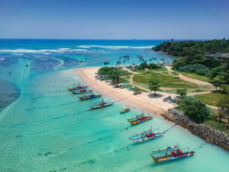 Malownicza plaża z łodziami i krystalicznie czystą wodą. Sri Lanka