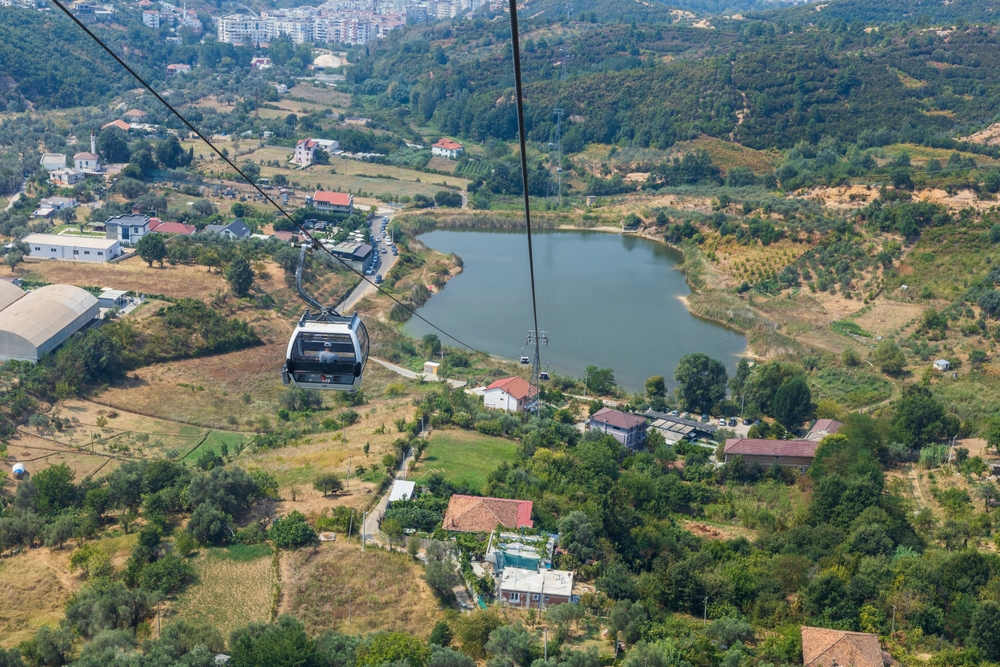 Kolejka linowa Dajti Ekspres nad zieloną doliną pod Tiraną, w dole jezioro