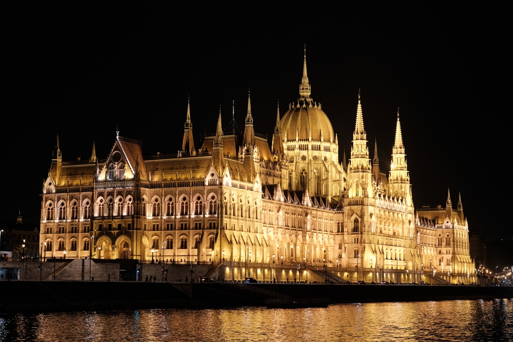 Parlament w Budapeszcie oświetlony nocą nad Dunajem