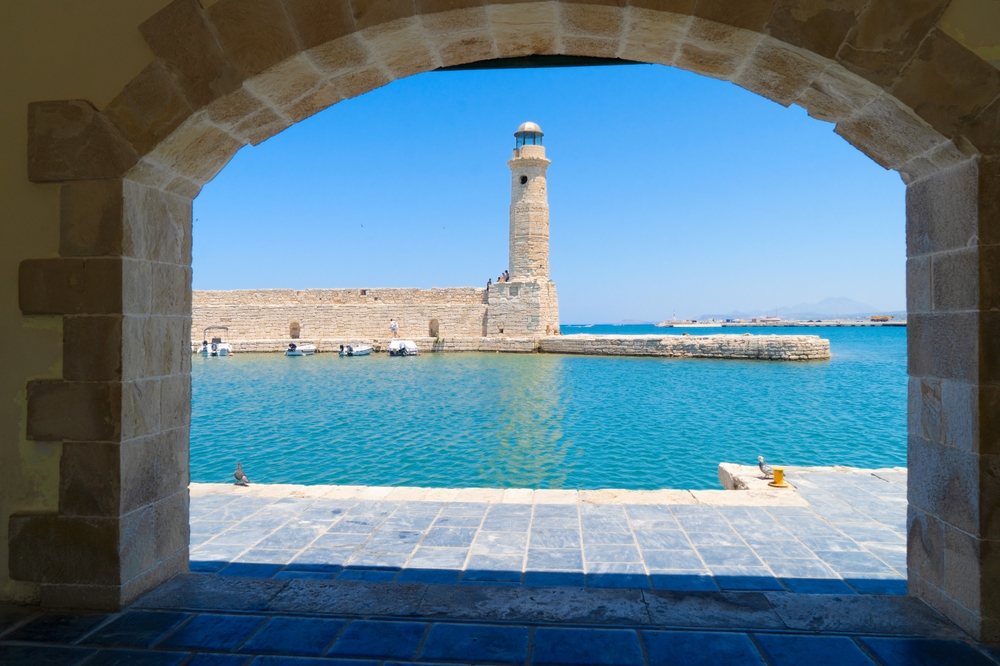 Egipska latarnia morska w Rethymno z 1830 r. widziana przez kamienny łuk
