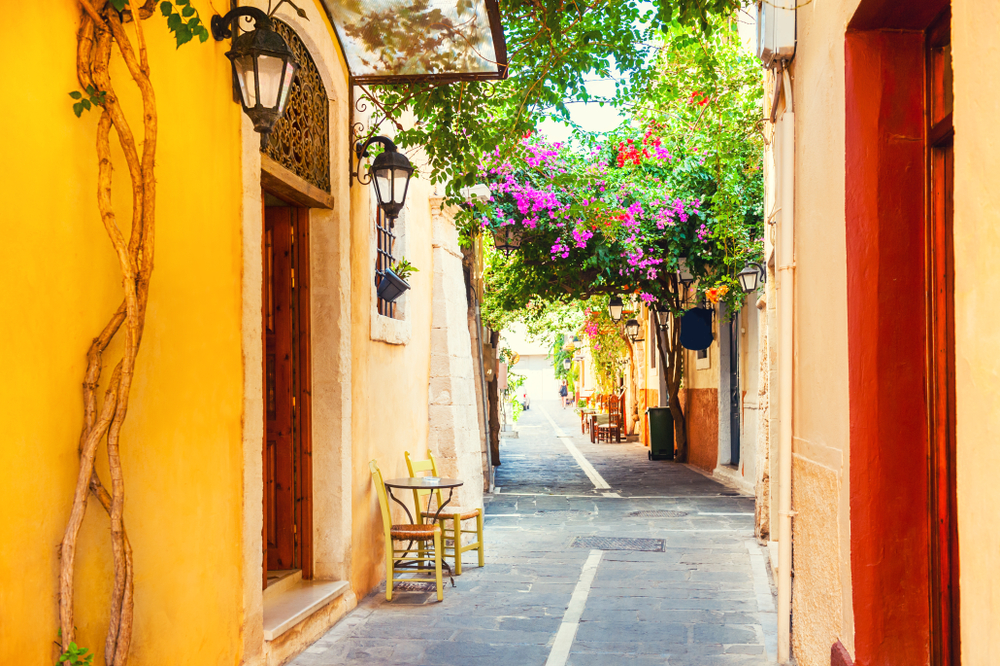Uliczka starego miasta w Rethymno z bougainvillą i kawiarnią pod żółtą fasadą