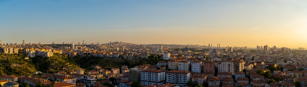 Panoramiczny widok na Ankarę o zachodzie słońca z gęstą zabudową miejską i meczet w tle