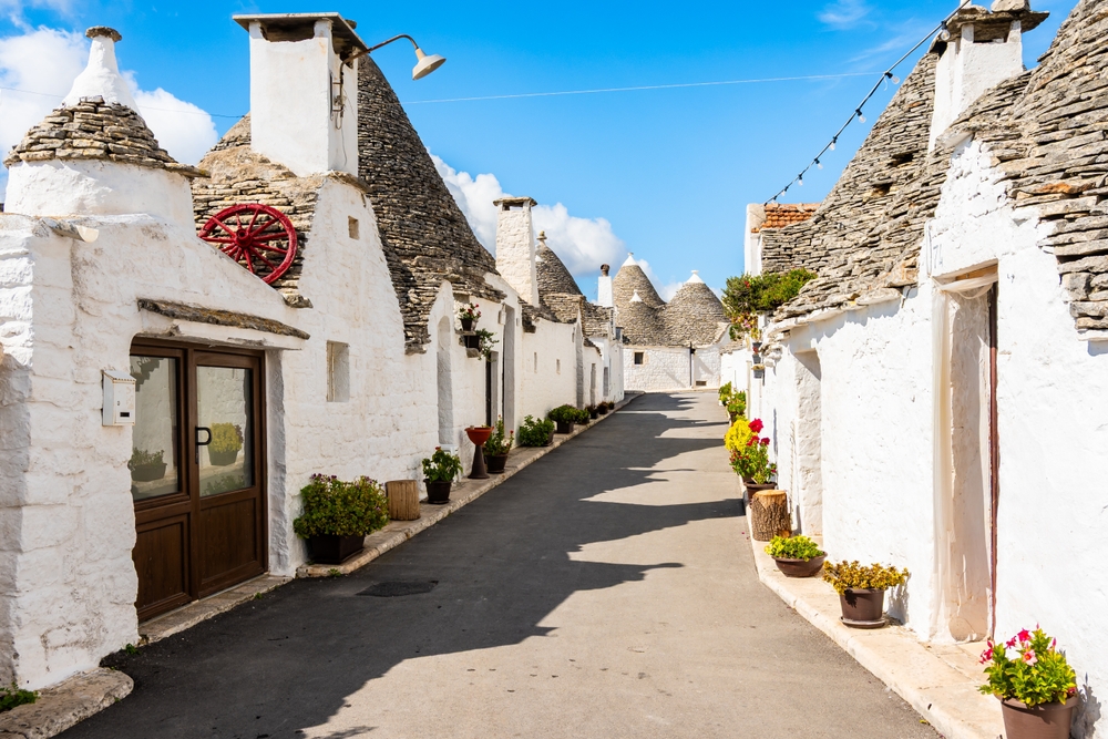 Alberobello w Apulii - białe trulli z kamiennymi stożkowymi dachami