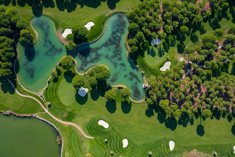 Widok z lotu ptaka na pole golfowe w Belek, Turcji z jeziorami, bunkrami piaskowymi i zielonymi fairwayami otoczonymi drzewami
