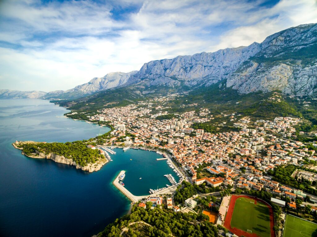 Makarska z lotu ptaka, port i zabudowa miasta u stóp masywu Biokovo