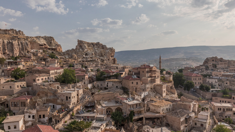 Panorama Ürgüp ze wzgórza Temenni: domy skalne, minaret i dolina Kapadocji