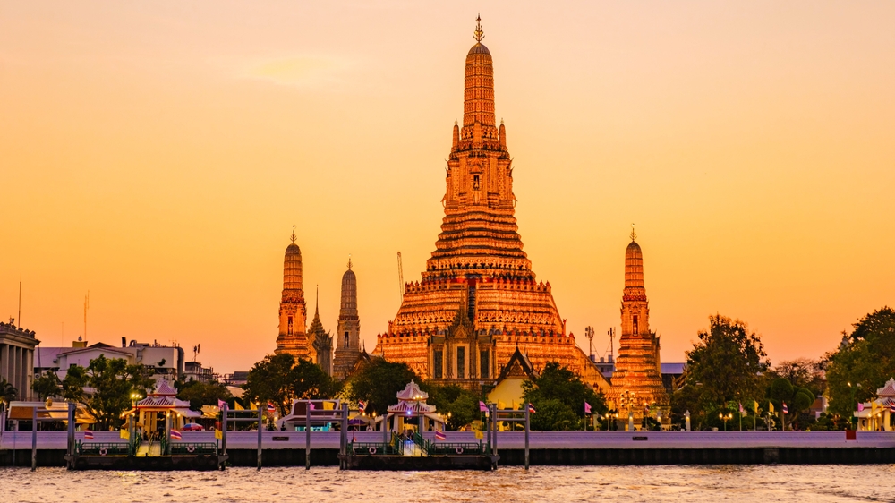 Świątynia Wat Arun nad rzeką Chao Phraya w Bangkoku o zachodzie słońca