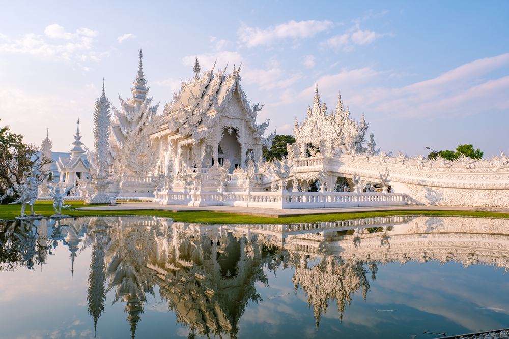 Biała Świątynia Wat Rong Khun w Chiang Rai z ozdobnymi mostami i figurami