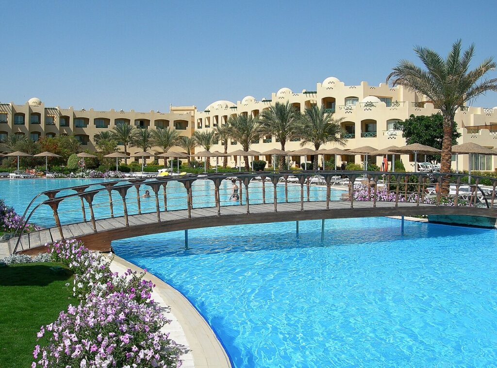 Basen z drewnianym mostkiem przed hotelem w stylu arabskim w Makadi Bay