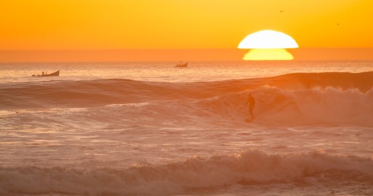 Surfer na fali o zachodzie słońca u wybrzeża Taghazout
