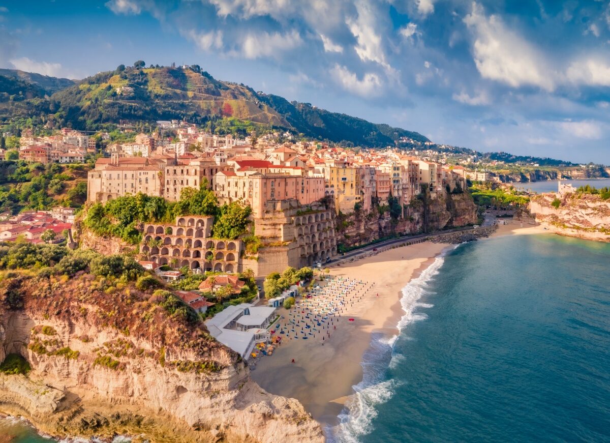 Tropea z lotu ptaka: starówka na klifie, plaża z parasolami i skała sanktuarium