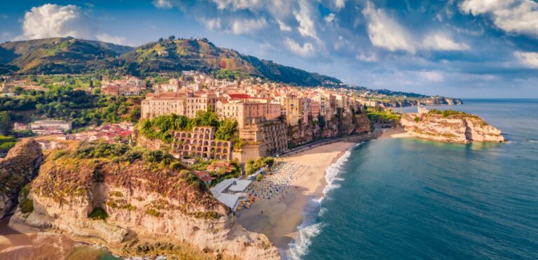 Tropea z lotu ptaka: starówka na klifie, plaża z parasolami i skała sanktuarium