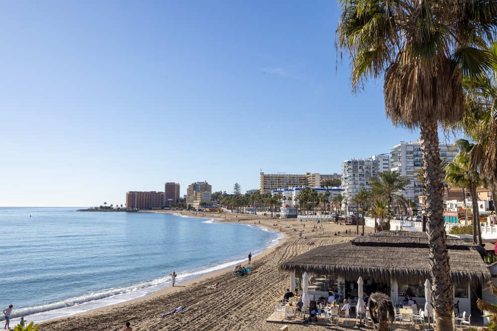 Plaża w Benalmádenie z chiringuito pod strzechą, za nią hotele pierwszej linii