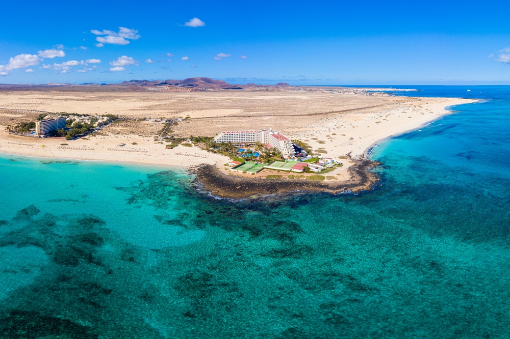 Grandes Playas w parku wydmowym Corralejo z lotu ptaka, hotele na cyplu nad rafą