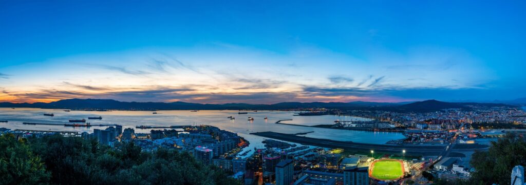 Panorama Gibraltaru o zmierzchu, pas startowy, port i statki na redzie