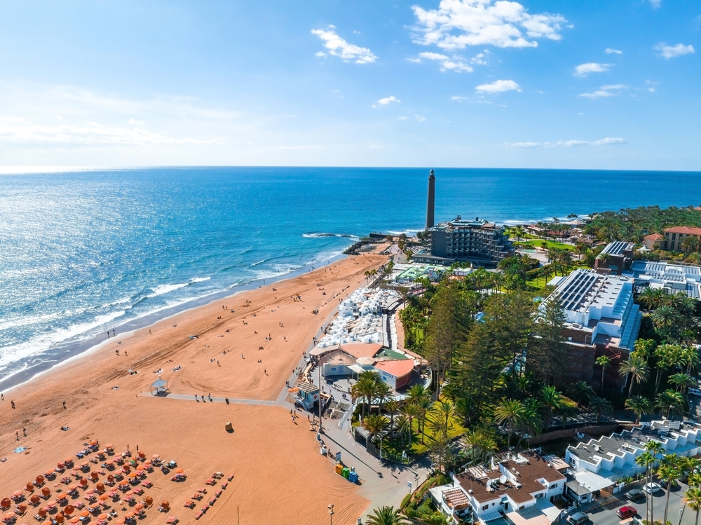 Plaża Maspalomas z lotu ptaka, latarnia na krańcu pasa i parasole przy promenadzie