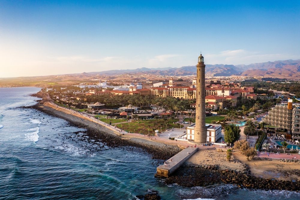 Latarnia Maspalomas nad brzegiem, deptak El Faro i zabudowa Meloneras w tle