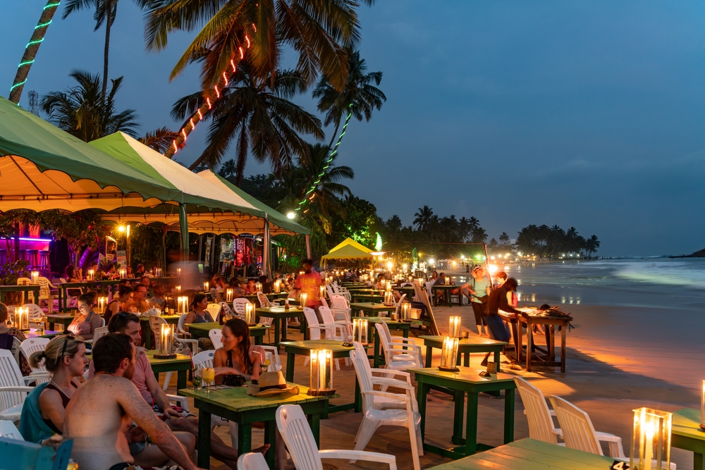Restauracje ze stolikami na plaży w Mirissie wieczorem