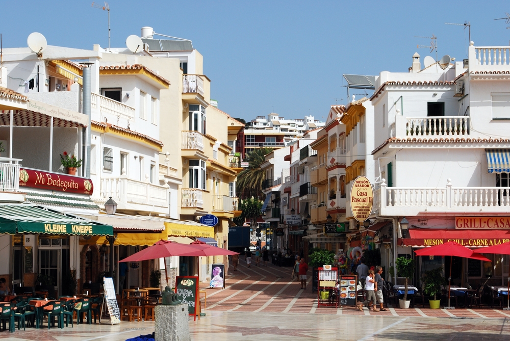 Deptak w Torremolinos, restauracje z markizami i stoliki po obu stronach