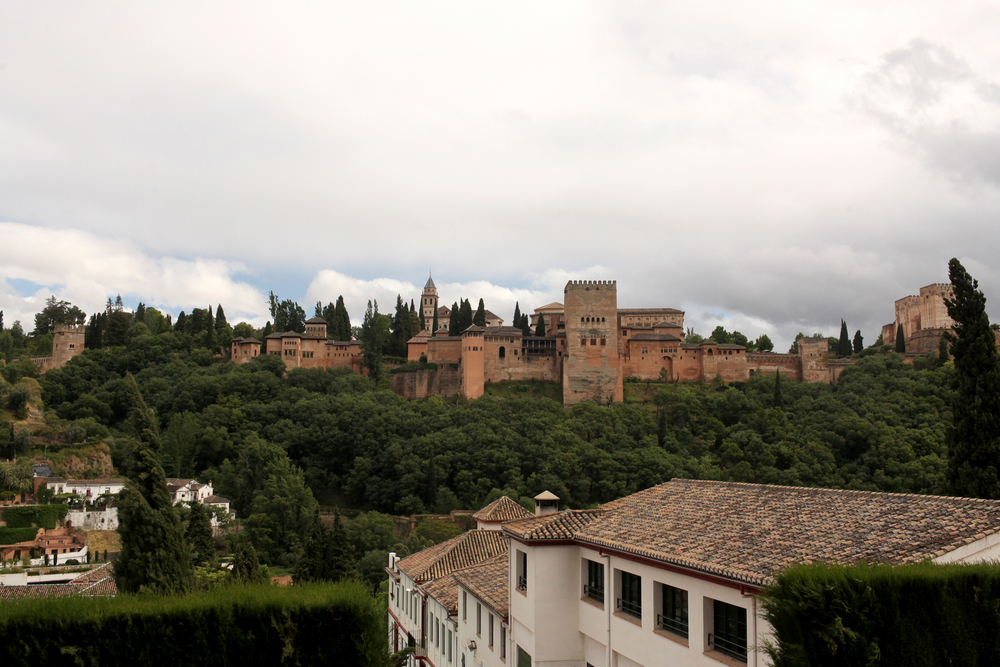 Alhambra widziana z przeciwległego wzgórza, mury nad zielonym zboczem