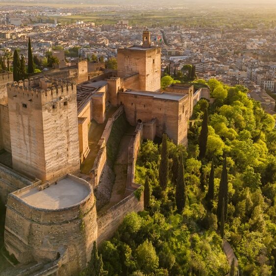 Alcazaba, warowna część Alhambry w Grenadzie, z miastem w tle o świcie