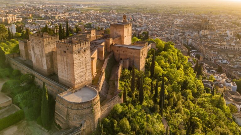 Alcazaba, warowna część Alhambry w Grenadzie, z miastem w tle o świcie