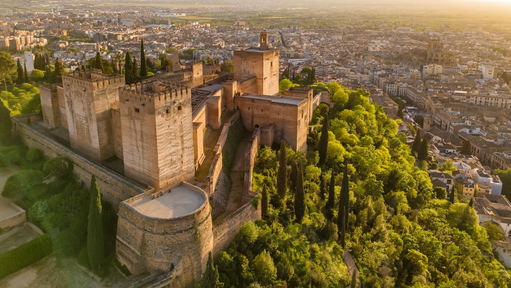 Alcazaba, warowna część Alhambry w Grenadzie, z miastem w tle o świcie