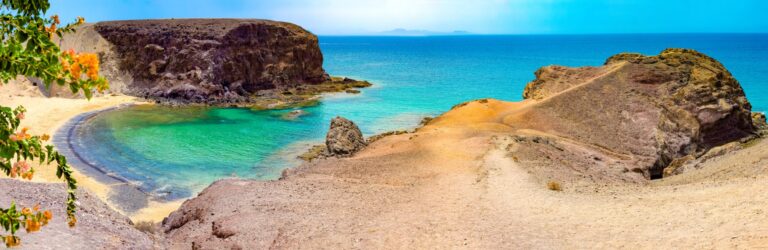 Zatoka Papagayo na Lanzarote, turkusowa woda między ochrowymi klifami