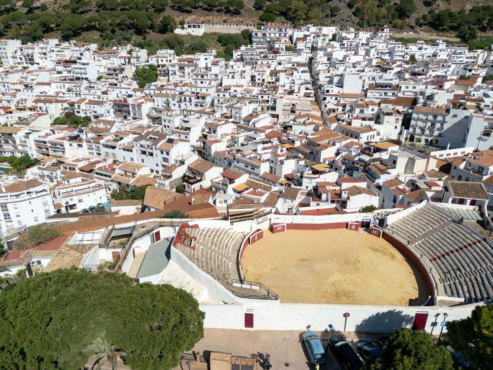 Owalna arena Plaza de Toros w Mijas Pueblo z lotu ptaka, wokół białe domy miasteczka