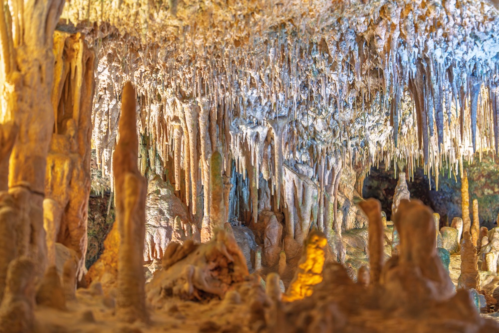 Stalaktyty i stalagmity w Jaskini Nerja, podświetlone formacje skalne pod stropem