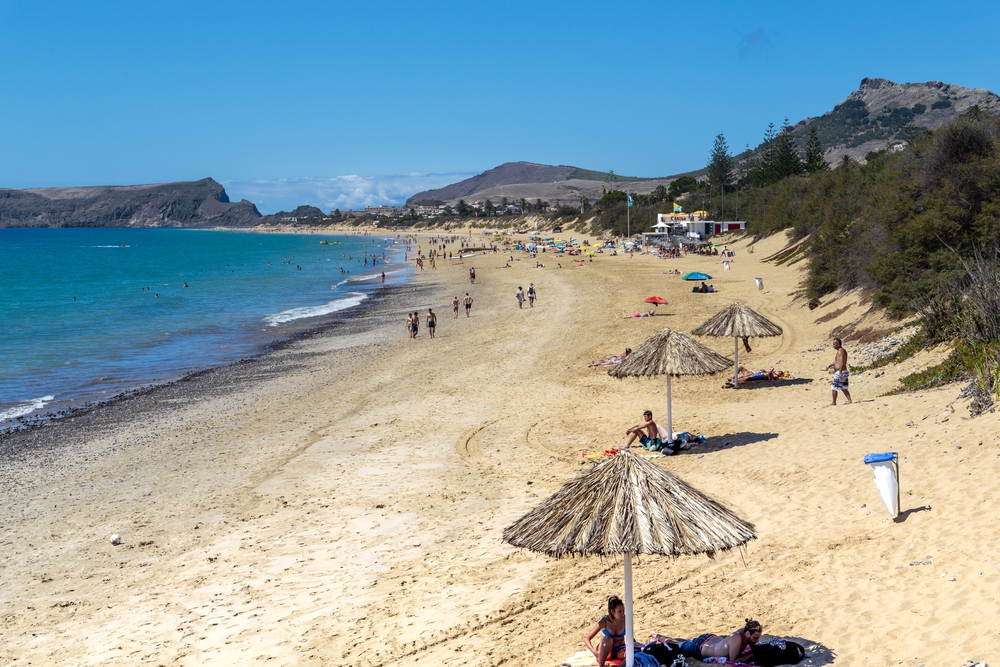 Złoty piasek plaży Porto Santo ze słomianymi parasolami