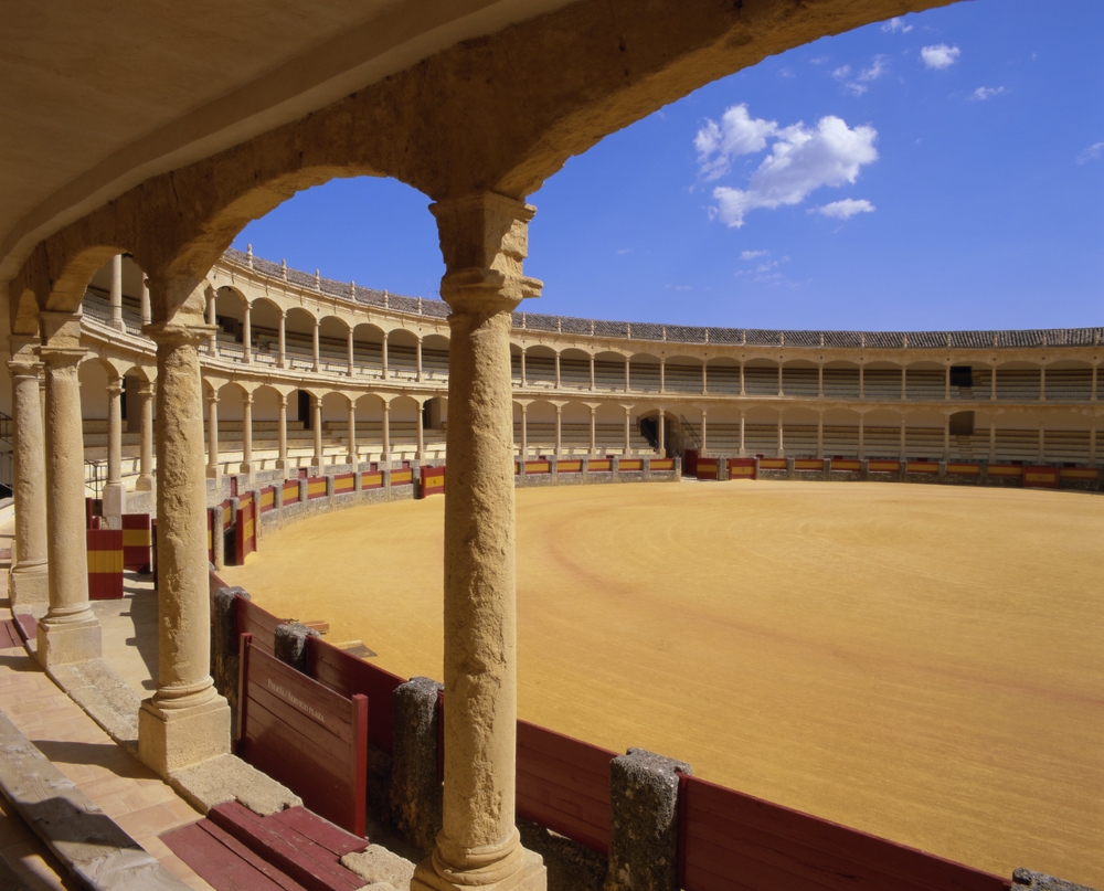 Arena Plaza de Toros w Rondzie: piaszczysty plac i dwa rzędy kamiennych arkad