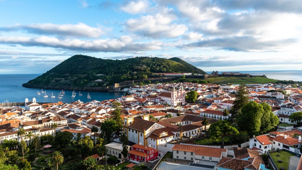 Stare miasto Angra do Heroísmo z czerwonymi dachami, port i zielony półwysep Monte Brasil nad zatoką
