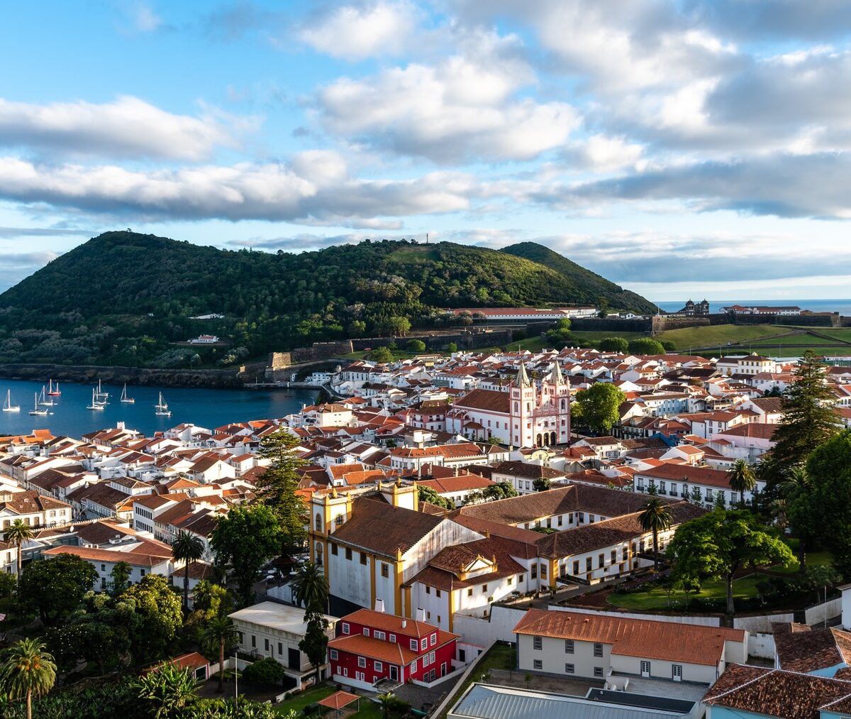 Stare miasto Angra do Heroísmo z czerwonymi dachami, port i zielony półwysep Monte Brasil nad zatoką