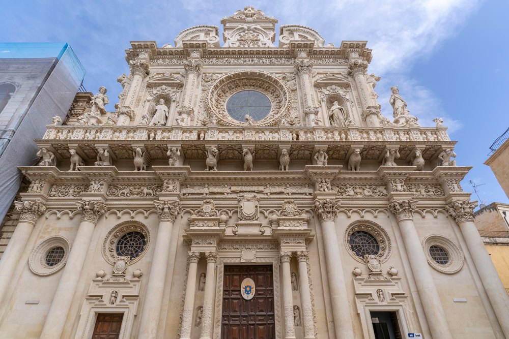 Barokowa fasada Bazyliki Santa Croce w Lecce z rozetą, rzeźbami i balustradą z jasnego kamienia