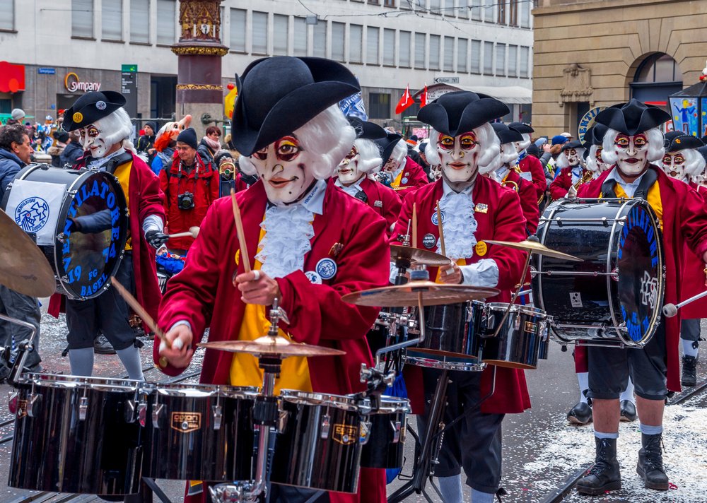 Bębniarze w maskach i czerwonych kostiumach na ulicy podczas Fasnacht w Bazylei