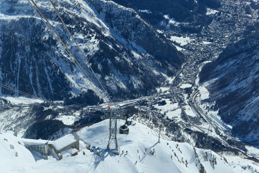 Courmayeur w dolinie pod masywem Mont Blanc zimą, widok z kolei Skyway na słup i kabinę