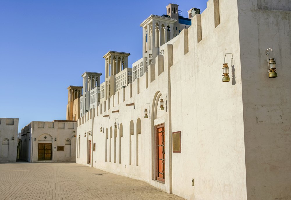 Białe mury i wieże wiatrowe odnowionych domów w dzielnicy Heart of Sharjah