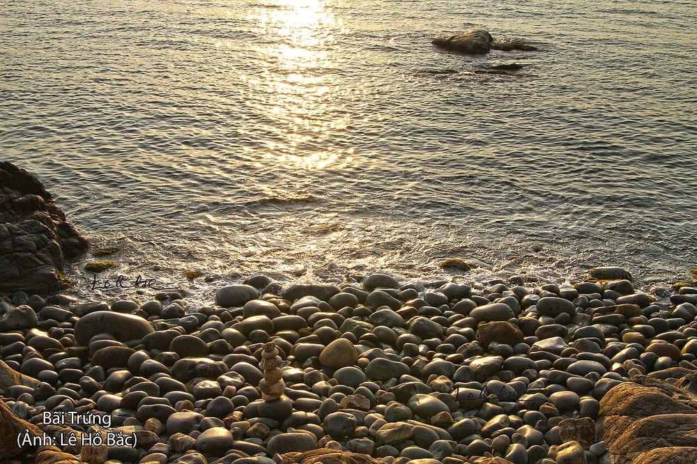 Obłe kamienie na brzegu plaży Hoàng Hậu na Ghềnh Ráng w porannym słońcu