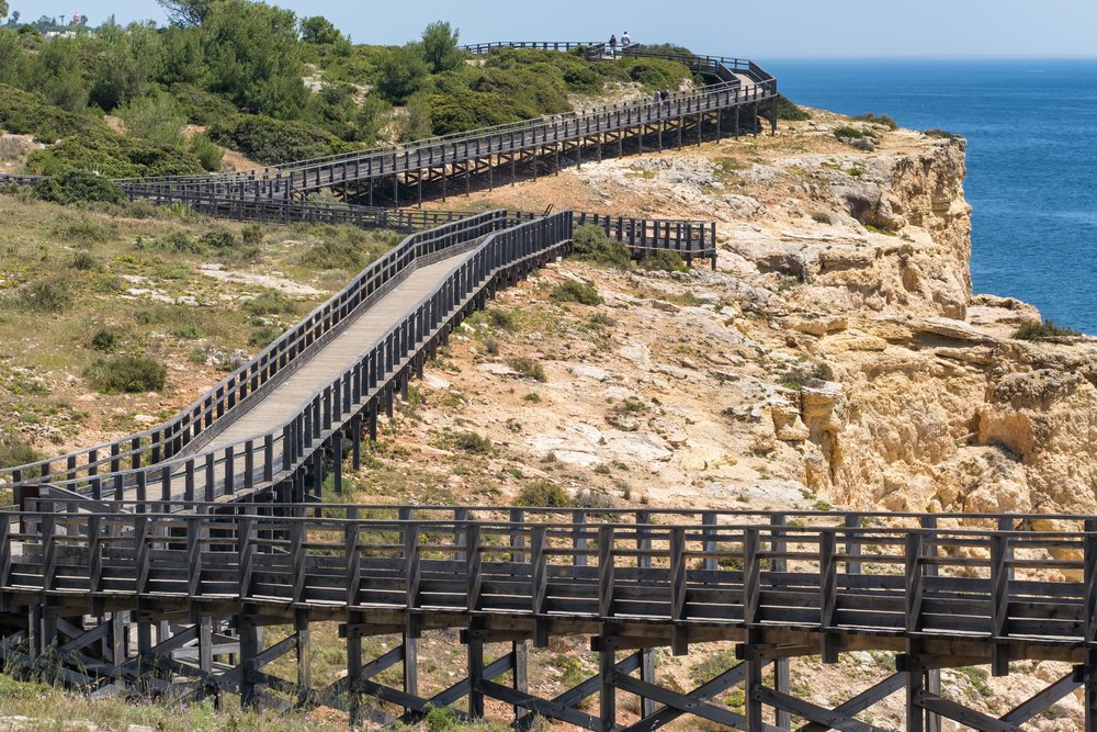 Drewniana kładka Caminho do Algar Seco wzdłuż klifu nad morzem w Carvoeiro