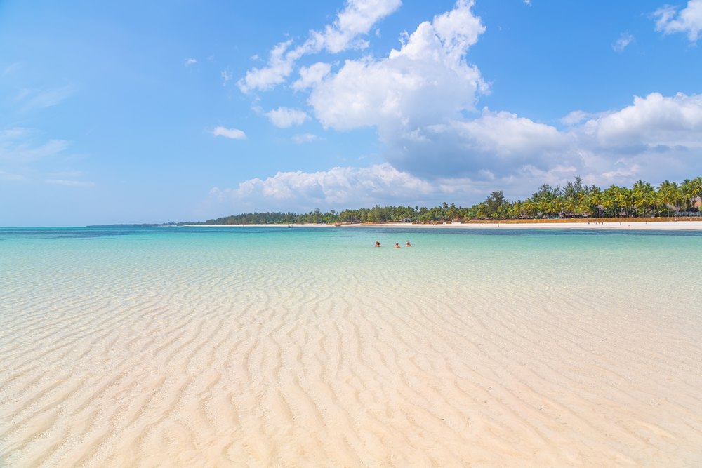 Płytka turkusowa woda i piaszczyste dno przy plaży Diani Beach