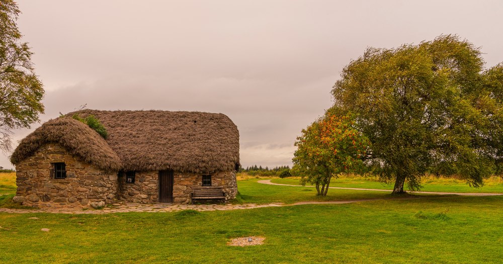 Kamienna chata Leanach Cottage z dachem krytym darnią na wrzosowisku Culloden