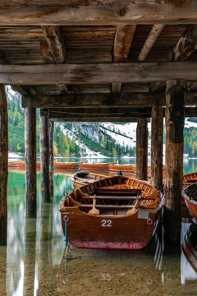 Drewniana łódź wiosłowa pod pomostem przystani na Lago di Braies