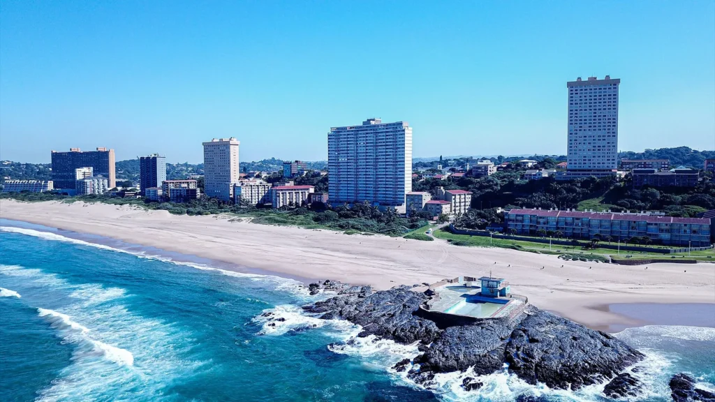 Main Beach w Amanzimtoti z lotu ptaka, skały w wodzie i wieżowce nad plażą