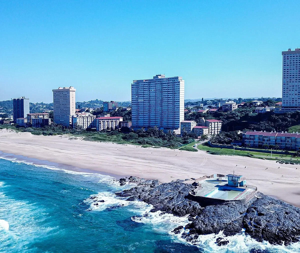 Main Beach w Amanzimtoti z lotu ptaka, skały w wodzie i wieżowce nad plażą