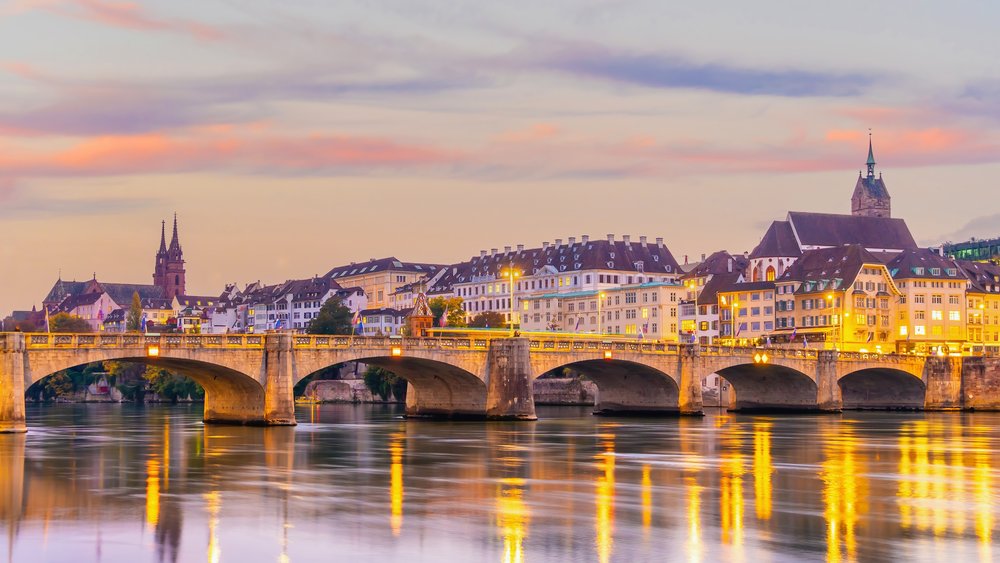 Oświetlony most Mittlere Brücke i Stare Miasto Bazylei wieczorem