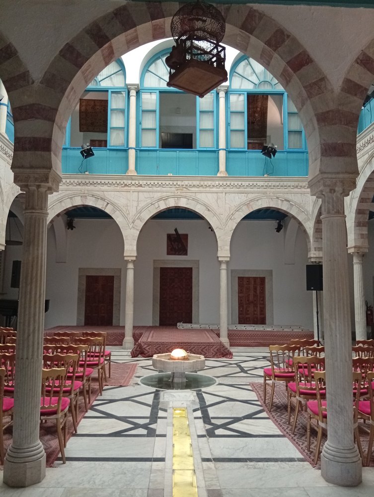 Patio pałacu Ennejma Ezzahra w Sidi Bou Said: arkady na kolumnach i marmurowa posadzka z fontanną