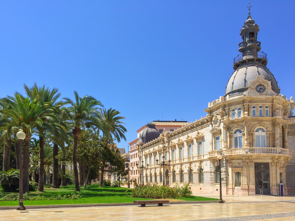 Modernistyczny ratusz Palacio Consistorial w Cartagenie z kopułą, obok palmy na placu